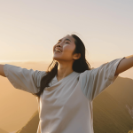 Person standing on a mountaintop at sunrise, representing self-discovery and a fresh start after a long-term relationship ends.